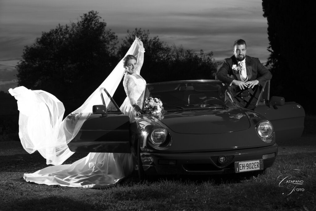 Durante il matrimonio di Serena e Manuel i due sposi sorridono vicino alla loro auto